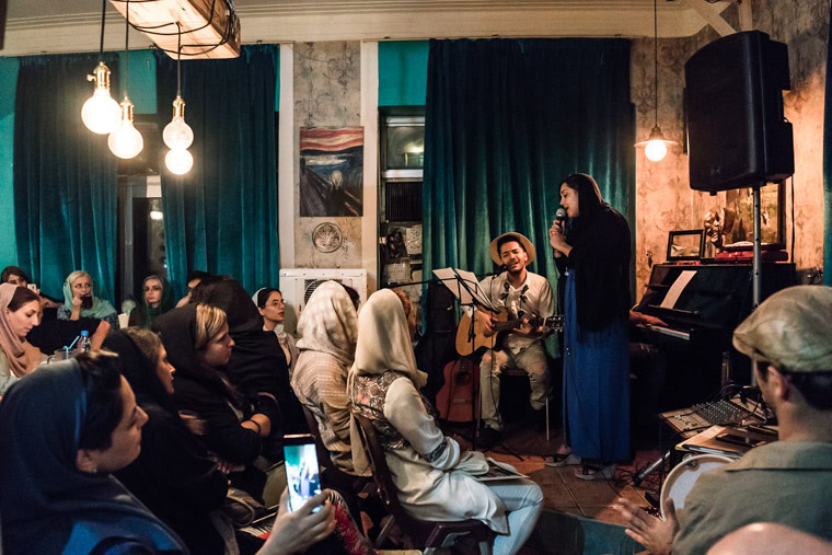 Iranian female vocalist singing in front of an audience at an open mic session in a cefe in Tehran, iran.