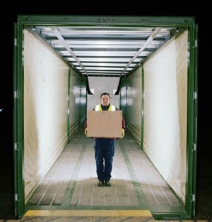 LTL Freight - Person holding a box inside of an empty LTL freight truck.