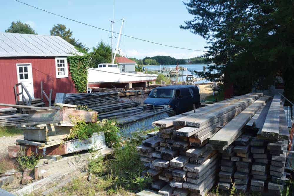 Stacked wood, a red shed, and a deadrise workboat on the railway—this must be the place: Butler’s famous Reedville Marine Railway.