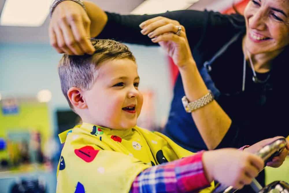 small boy gets haircut at Pigtails & Crewcuts kid's haircut franchise