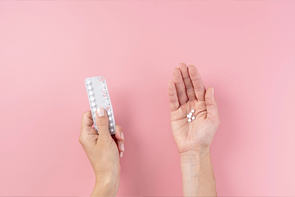Woman holding birth control pills in her hand