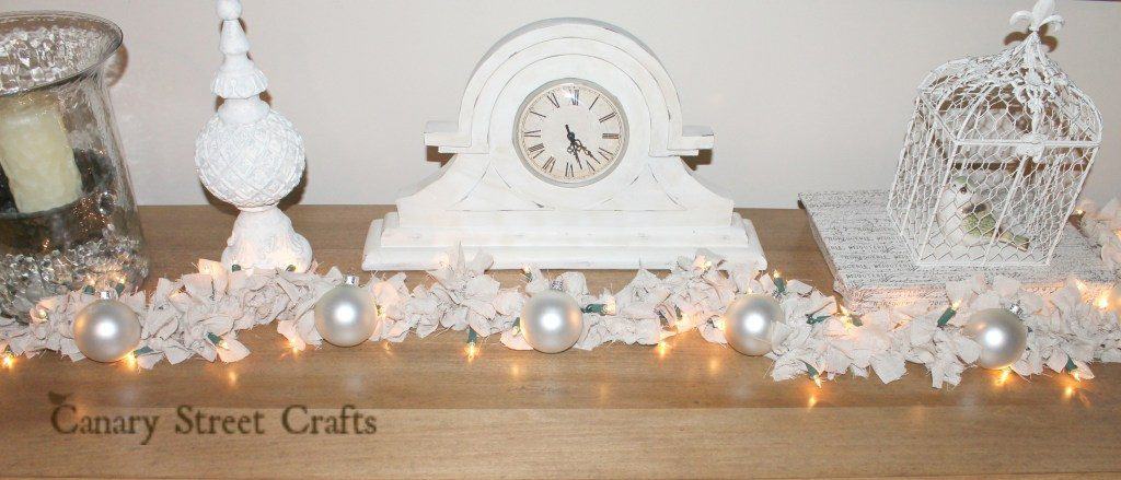rag diy christmas garland on table in front of clock