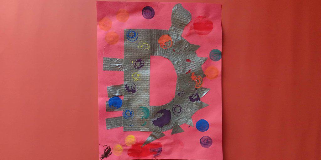 Picture of a preschooler's D is for dinosaur craft made from duct tape and dot markers