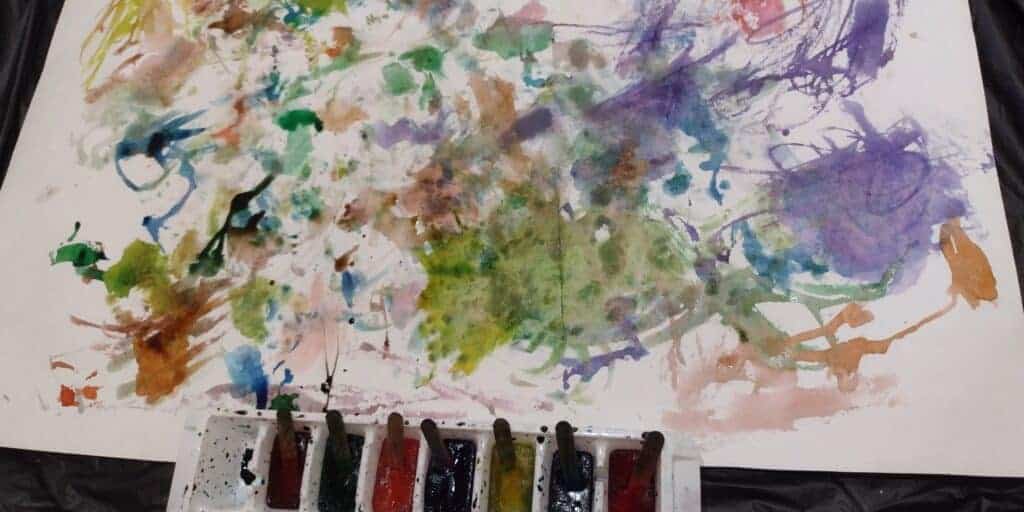 Picture of piece of paper after painting with ice. Colored ice cube sticks are in an ice cube tray at the bottom