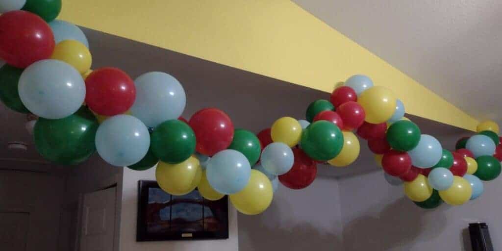 Picture from the side of a balloon garland made from red, green, yellow, and blue balloons