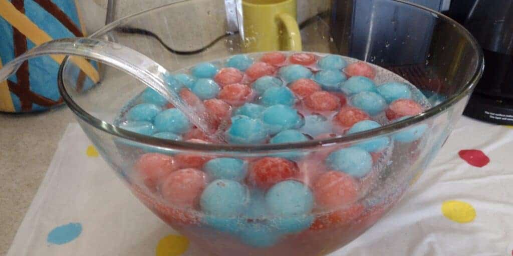 Picture of blue and red Kool-Aid ball ice cubes in a punch bowl filled with Sprite