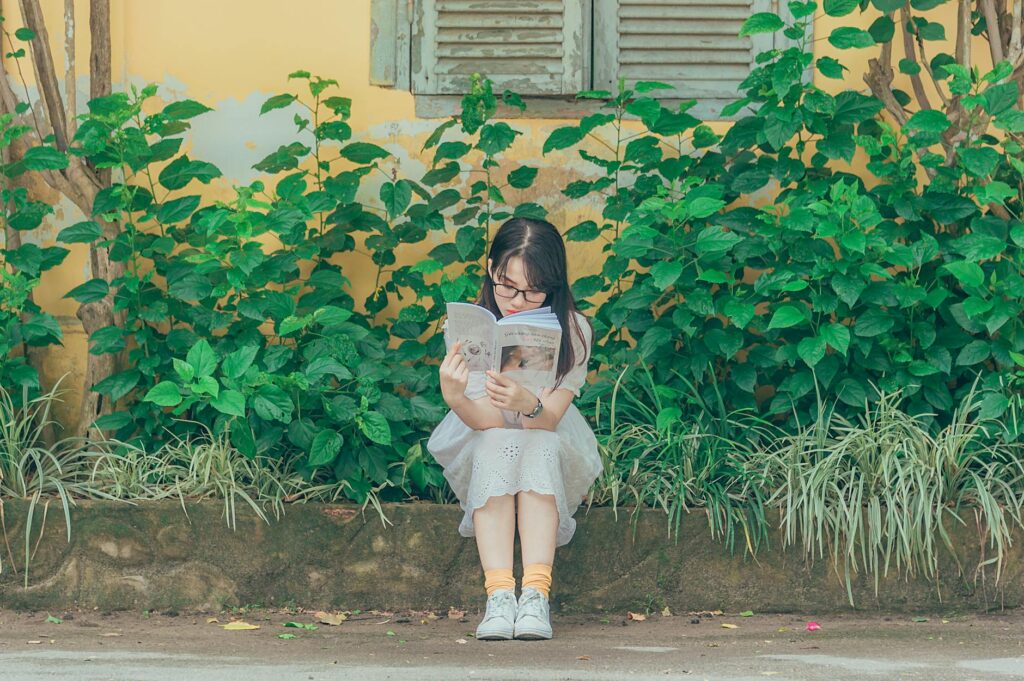 woman wearing white dress reading book