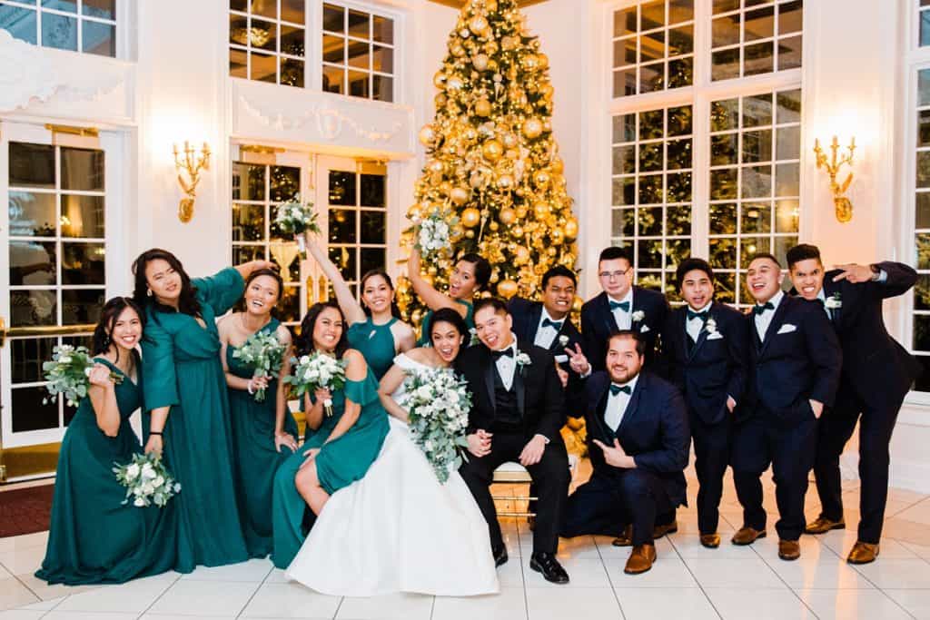 wedding bridal party goofy, funny portrait in the background Christmas tree