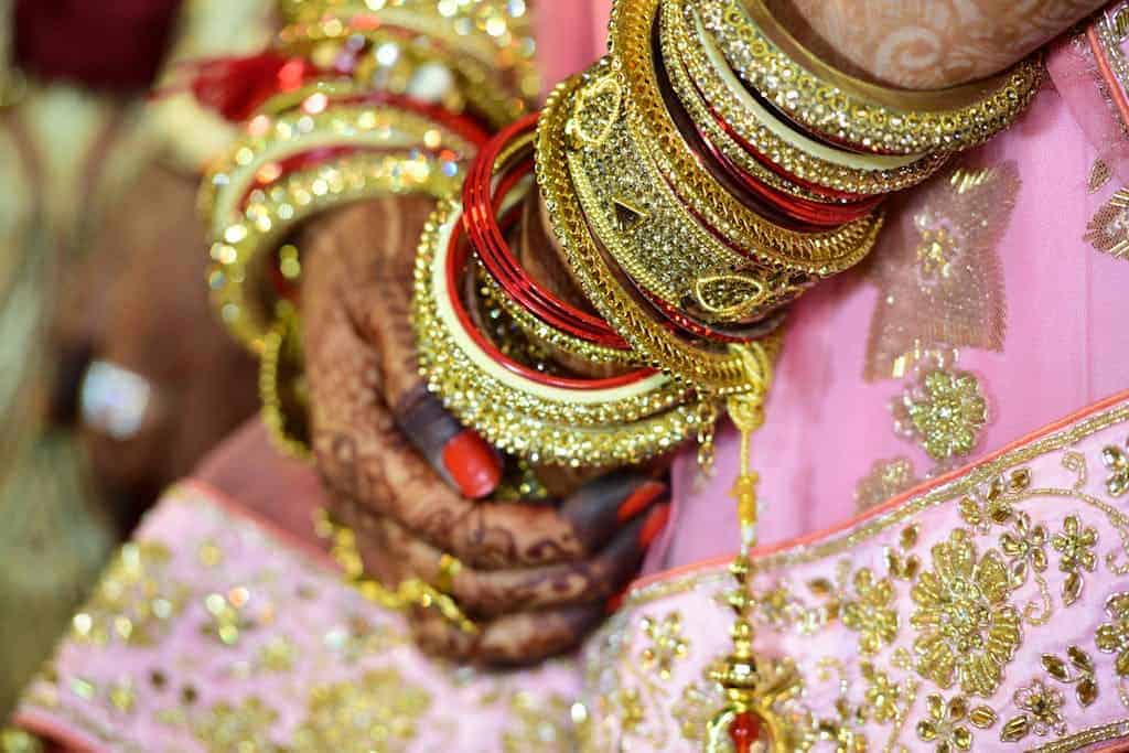 Woman Wearing Gold-colored Bangle and Mehndi
