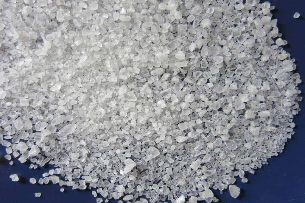 White rock salt spread out on a blue table