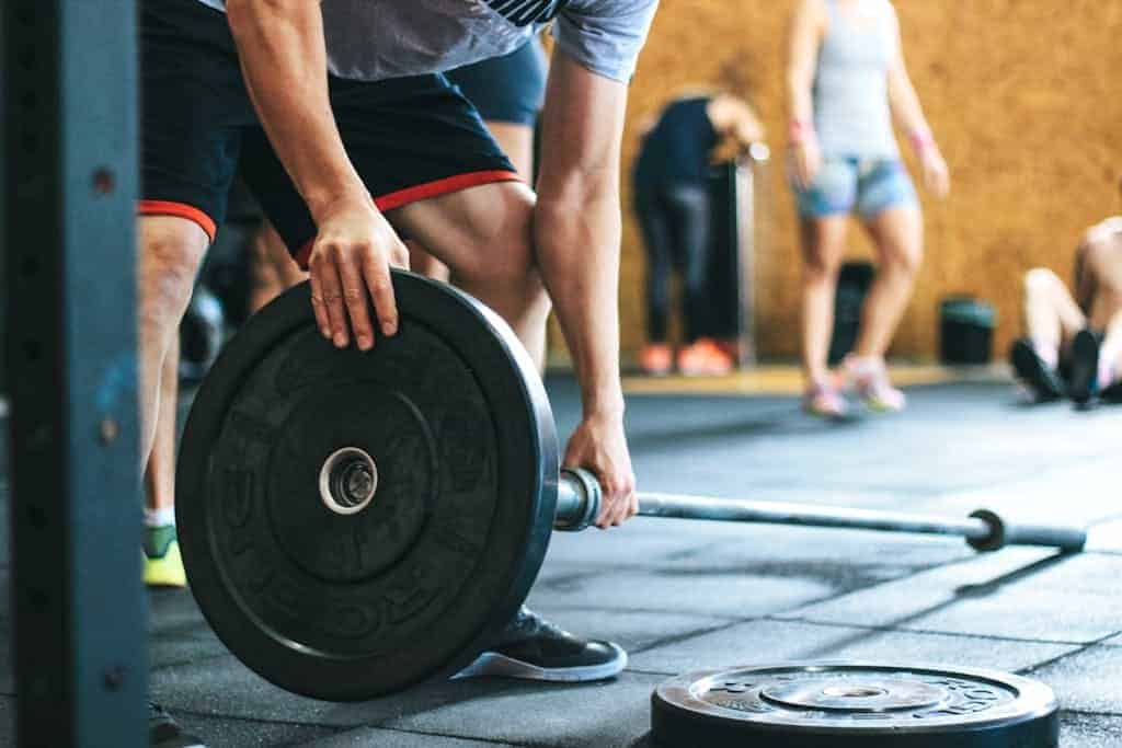 Focused weightlifting session in a gym with diverse athletes participating indoors.