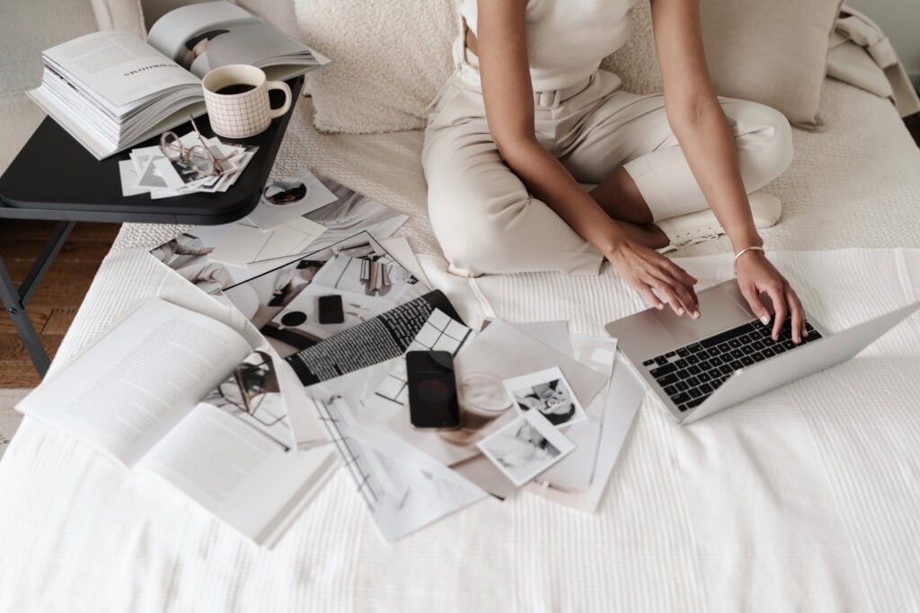 Person sits on bed surrounded by content ideas from their repurposed blogs