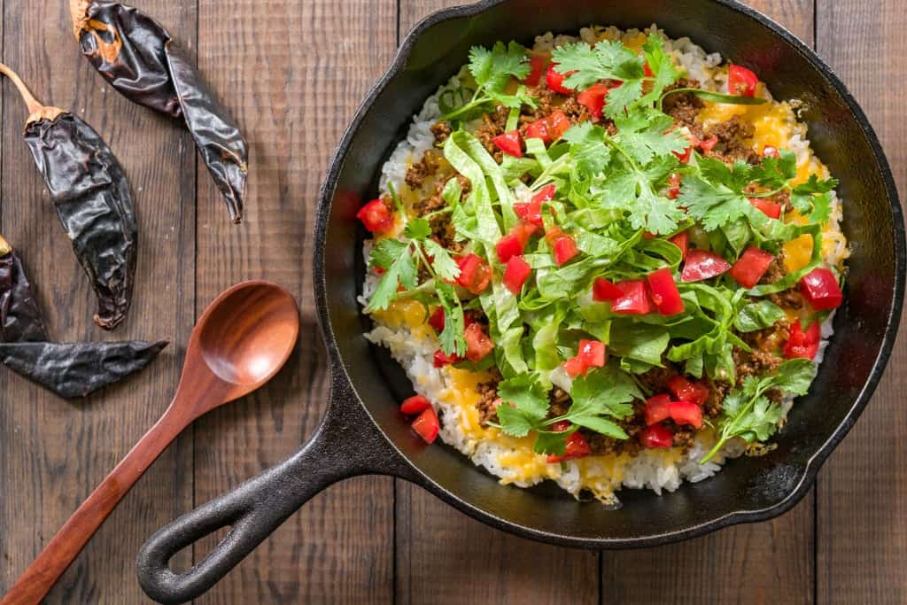 Crispy Taco Rice Recipe Taco Rice is a mashup of Japanese and Texmex cuisine with taco meat, cheese, lettuce and tomatoes on a bed of white rice.