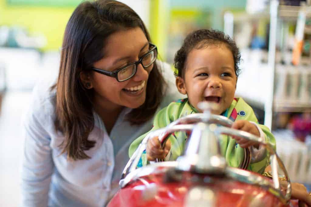 happy baby with mom at pigtails & crewcuts franchise