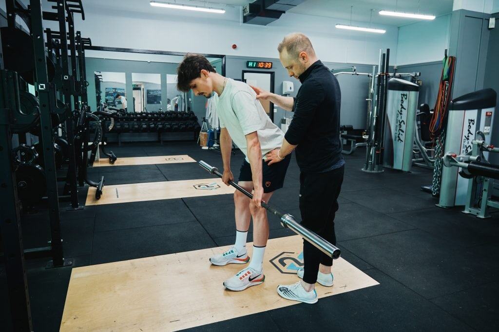 A sports therapist is helping a patient with an RDL exercise at seventy9 Sports Therapy, a sports injury clinic in Guildford, sports therapy in Guildford, sports massage in Guildford, sports therapy clinic in Guildford, sports massage clinic in Guildford