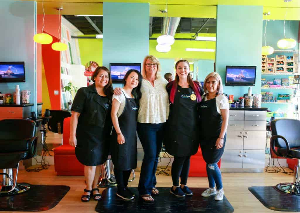 pigtails & crewcuts franchisee with staff in kids' haircut franchise