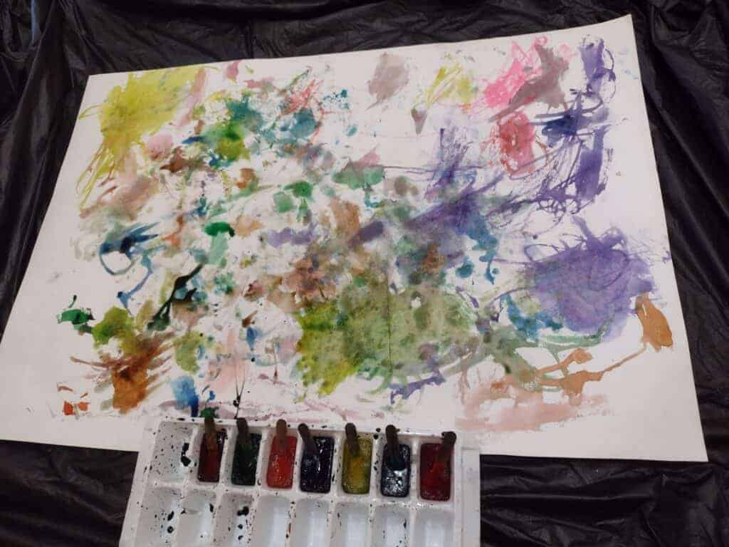 Picture of piece of paper after painting with ice. Colored ice cube sticks are in an ice cube tray at the bottom