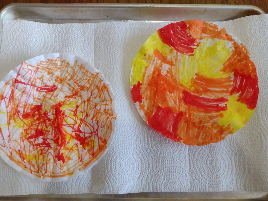 Picture of two stacks of coffee filters colored with red, yellow, and yellow markers as part of an easy pumpkin craft for kids