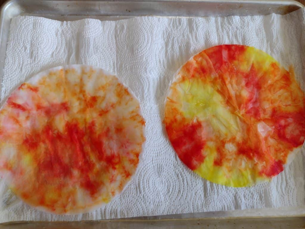 Picture of two coffee filters colored red, orange, and yellow and fully wet