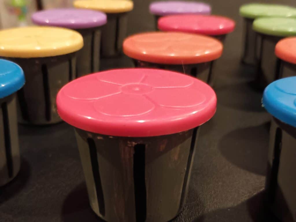 Picture of a bunch of Play Doh party favors painted to look like garbage cans with lids