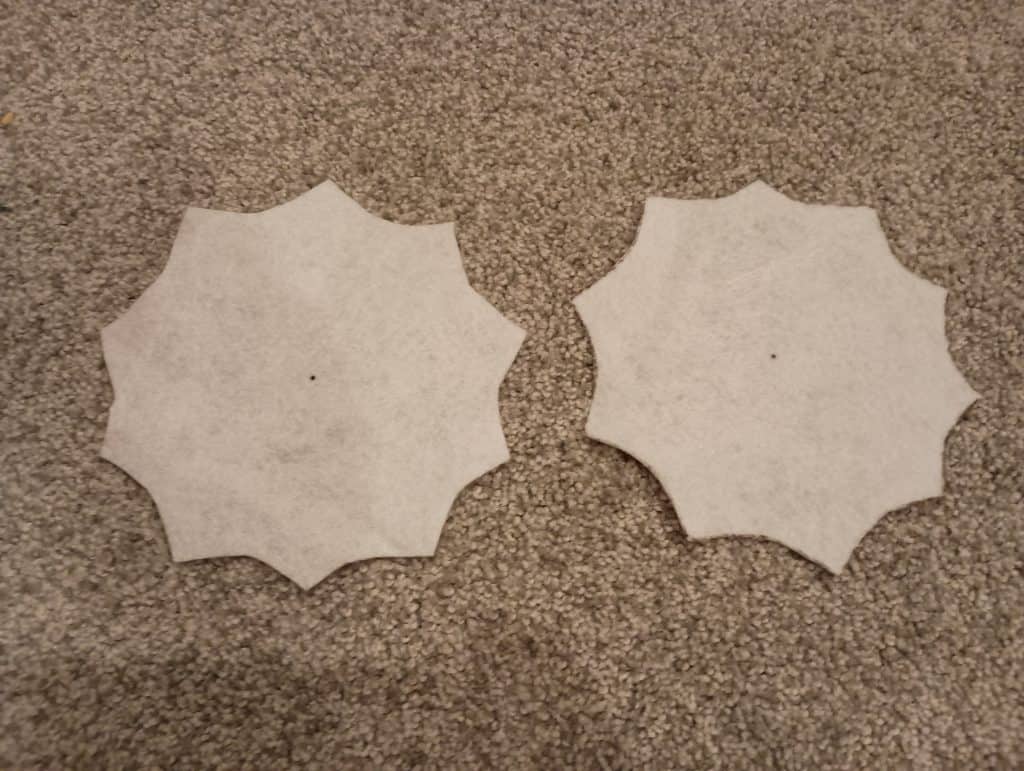 Picture of two pieces of felt cut in a spiderweb shape