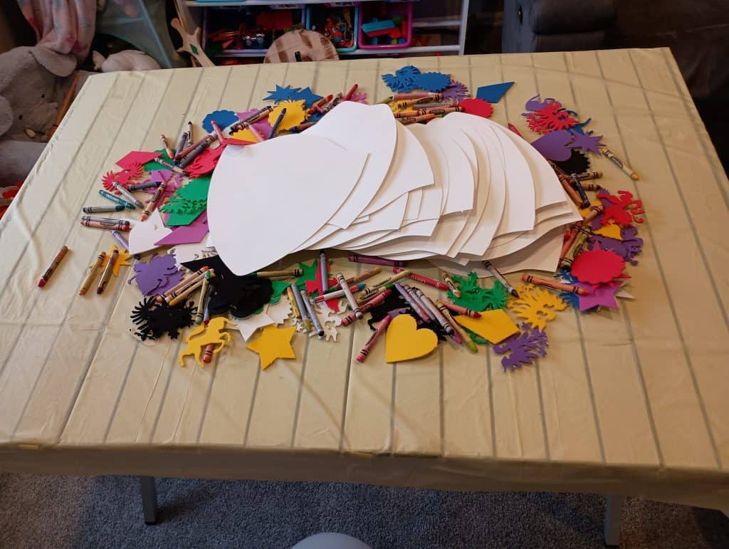 Picture of white paper shields, foam shapes, and crayons