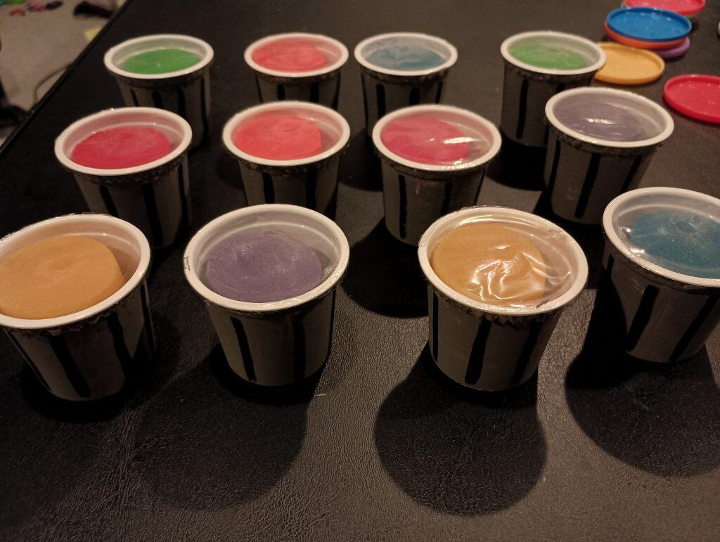 Picture of a bunch of Play Doh party favors painted to look like garbage cans with no lids