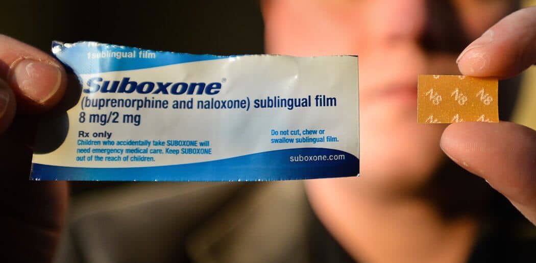 man holding suboxone package and drug