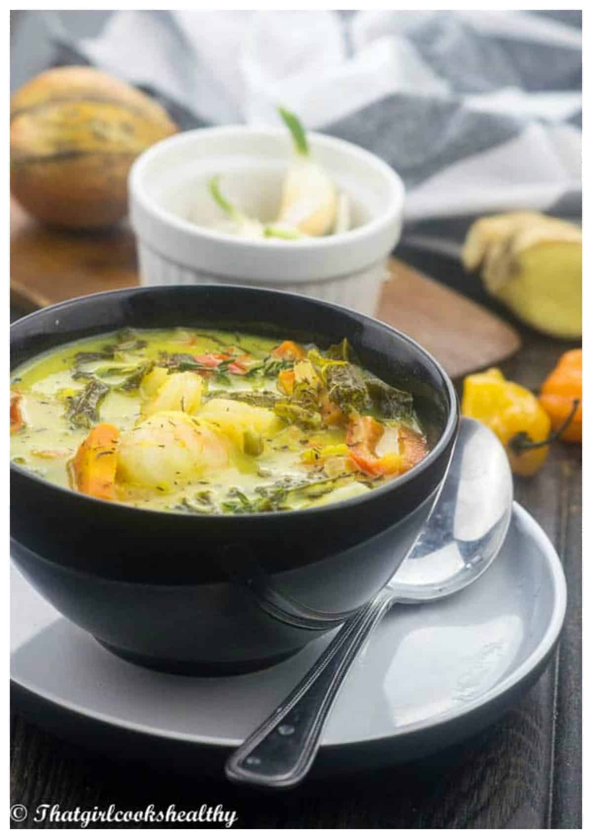 soup in a black bowl on a saucer