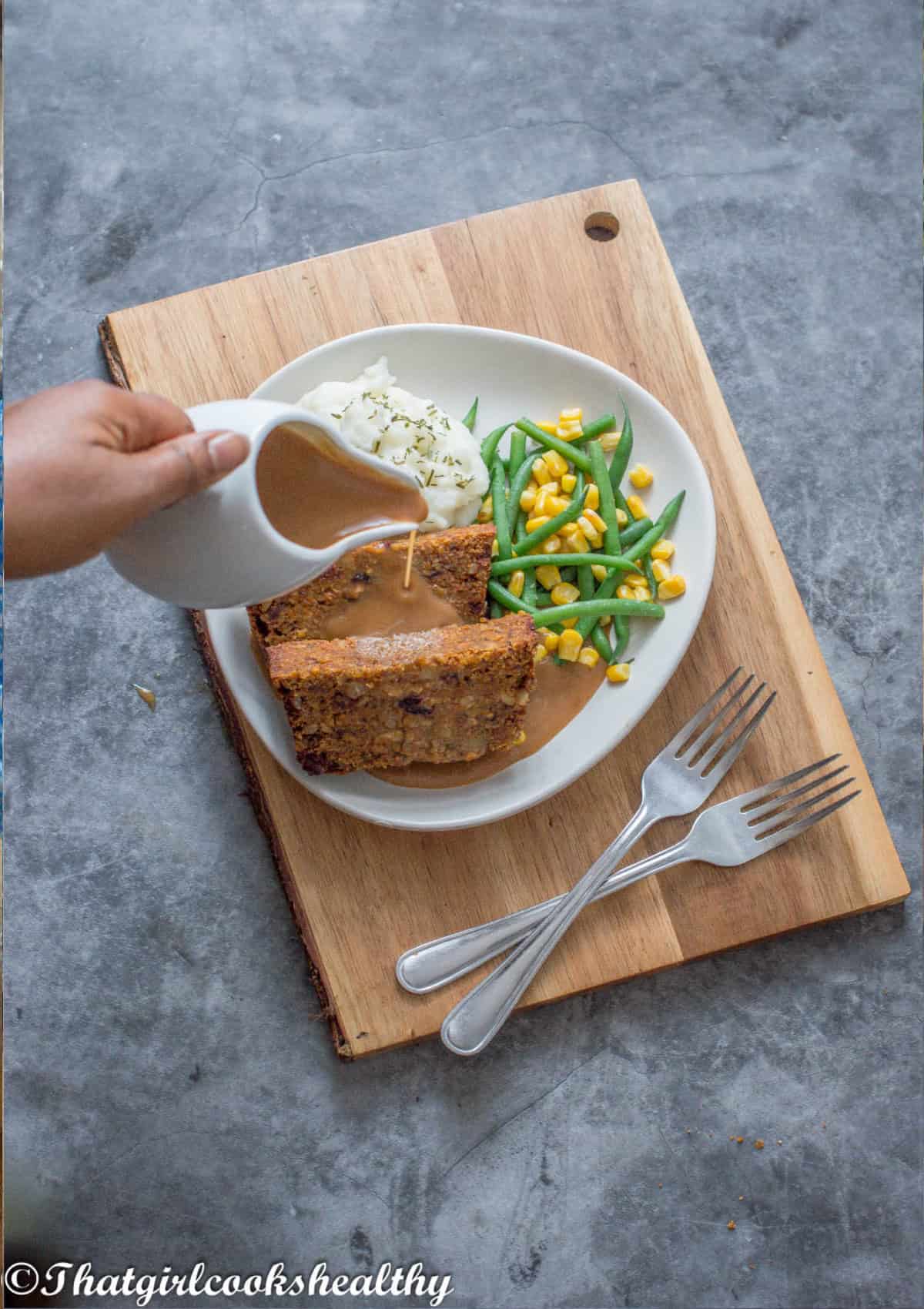 Pouring gravy onto the nut roast dinner