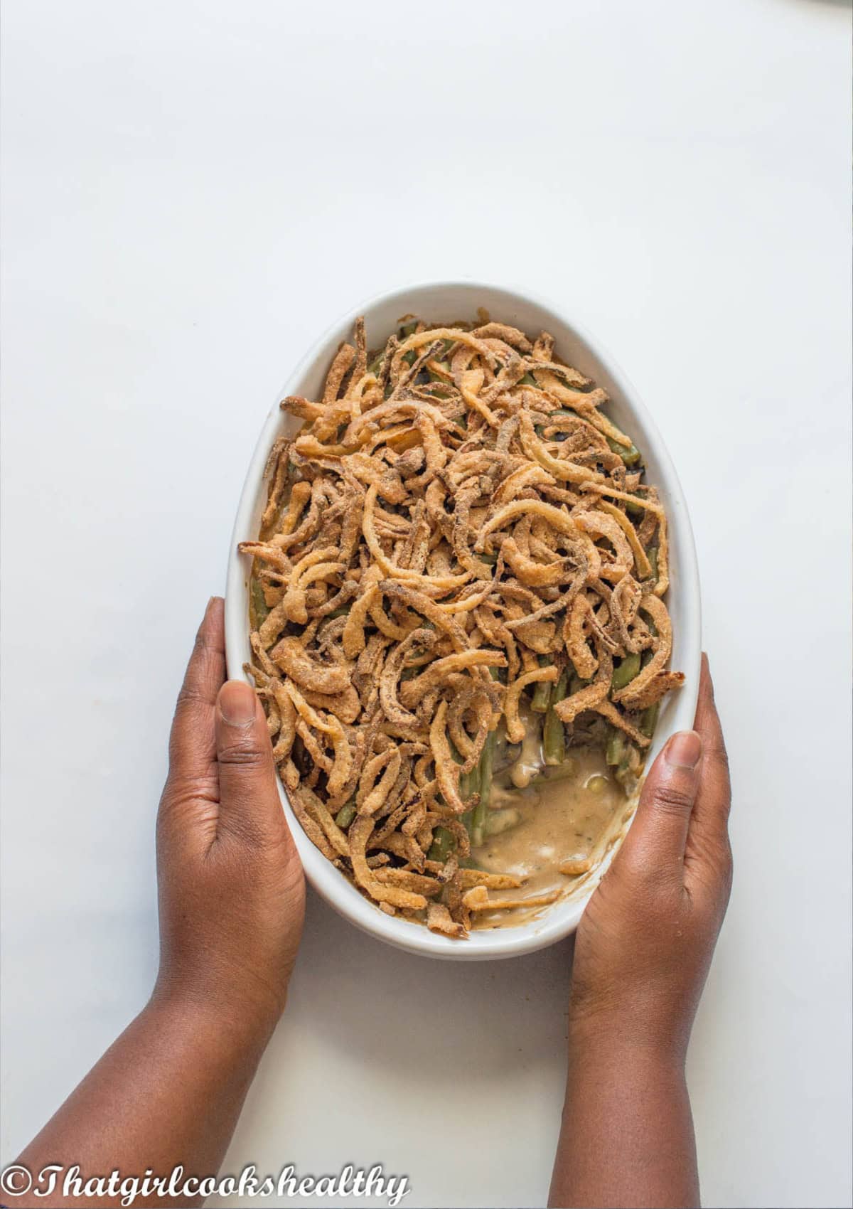 Pair of heads holding the dish with the green bean casserole