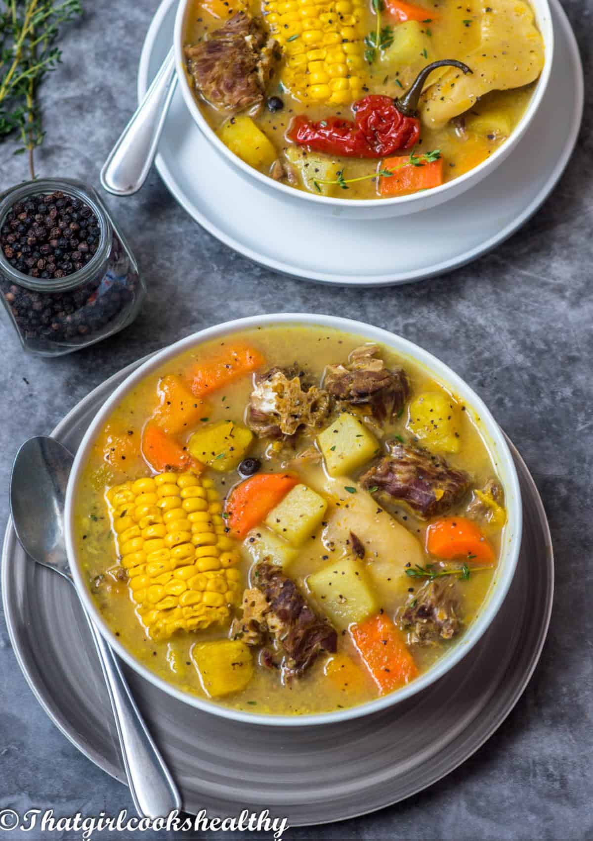 2 bowls of soup with meat and a mixture of vegetables