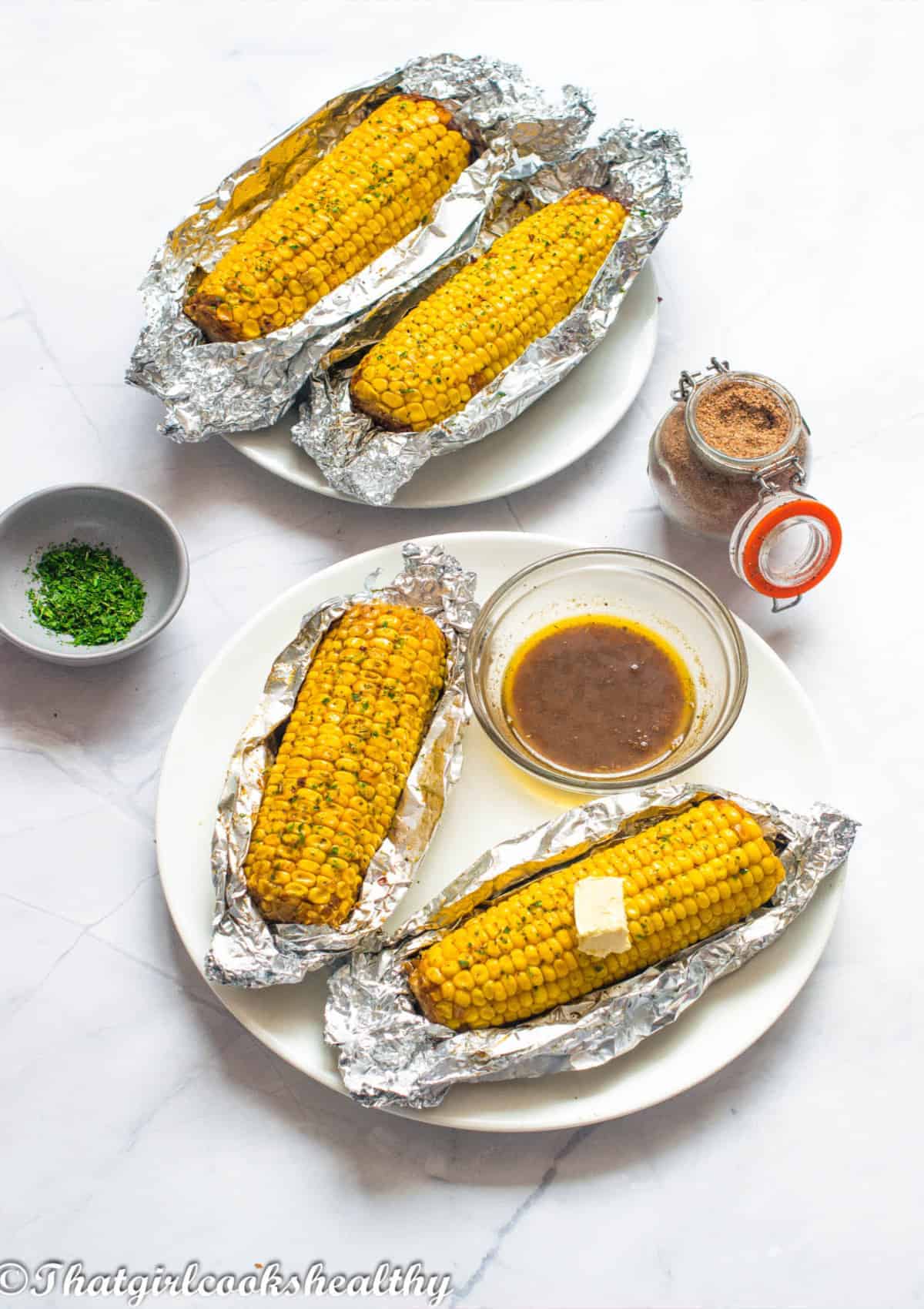 Corn in foil packets with a knob of butter.