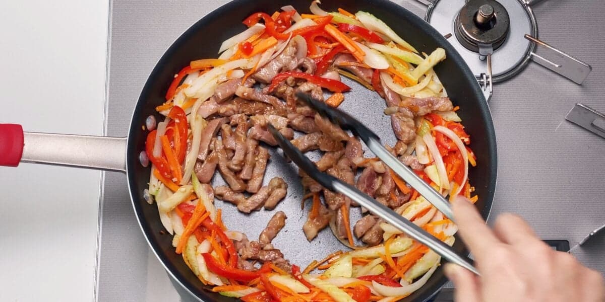 Stir-frying pork and vegetables for Chop Suey.
