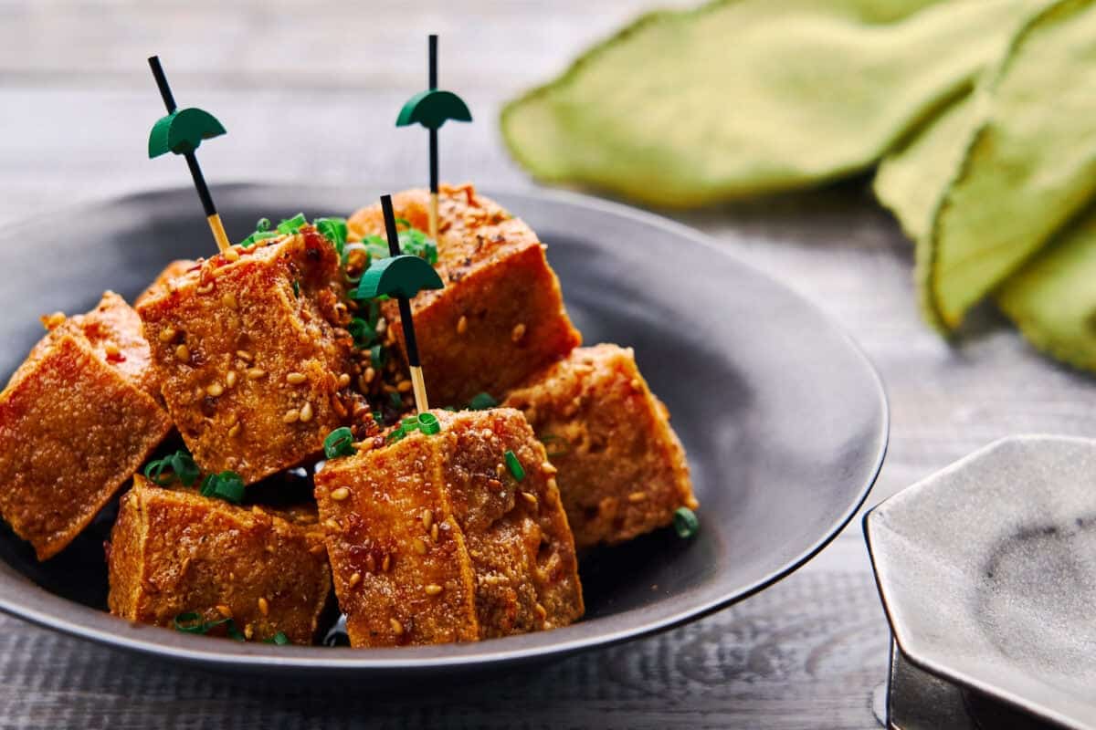 Shatteringly crisp cubes of tofu glazed in a savory-sweet ginger, garlic and black pepper sauce. A delicious plant-based canape.