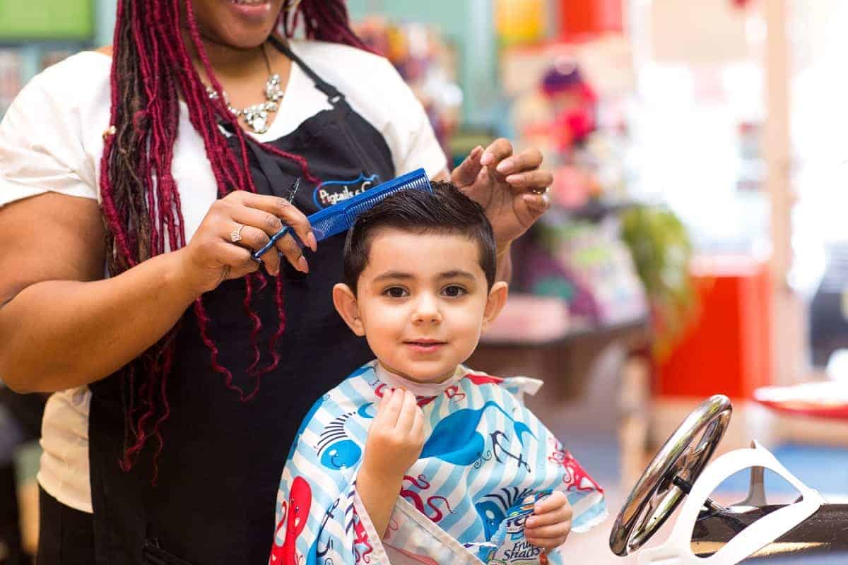 boy getting his hair cut at pigtails & crewcuts