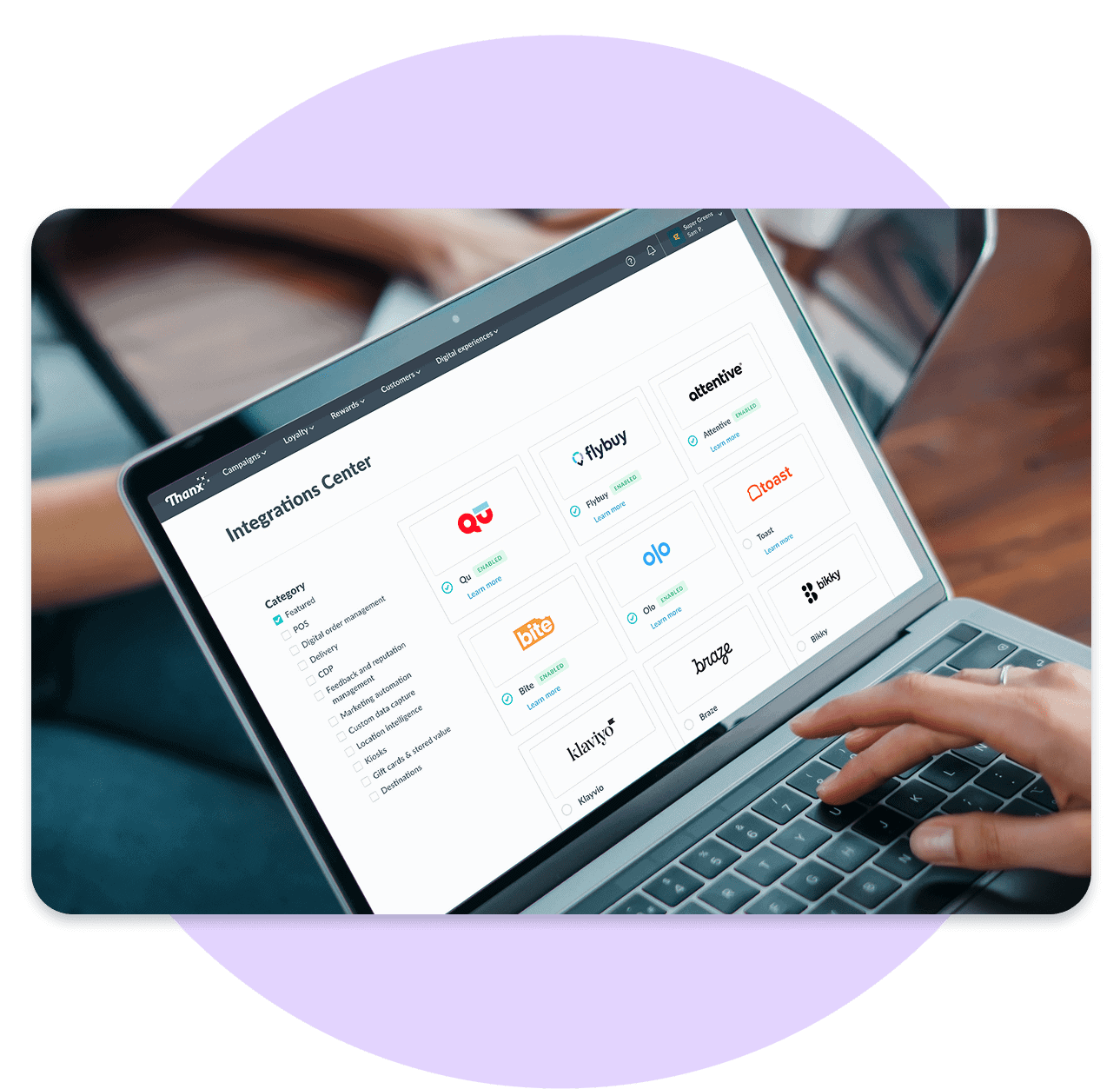 User interacting with the Thanx Integrations Center on a laptop, displaying a grid of partner logos such as Flybuy, Attentive, Qu, Toast, Olo, Bite, Klaviyo, and Braze, with filter options for categories like POS, email, and loyalty.