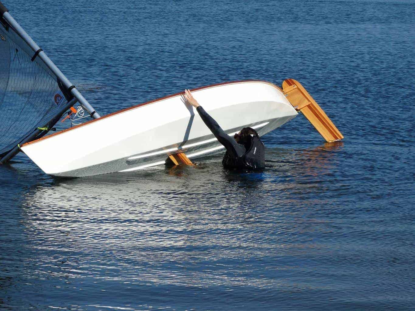 Woman sailor rights the Viola Sailing Canoe from capsize