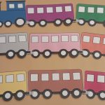 Picture of a train toy. There is a blue train engine followed by different colored train cars. They are laminated and attached together with hook and loop