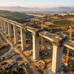Viaducto ferroviario en construcción visto desde drone aéreo profesional con luz dorada