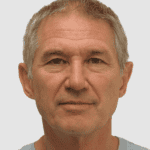 A man with graying hair and a gray t-shirt.