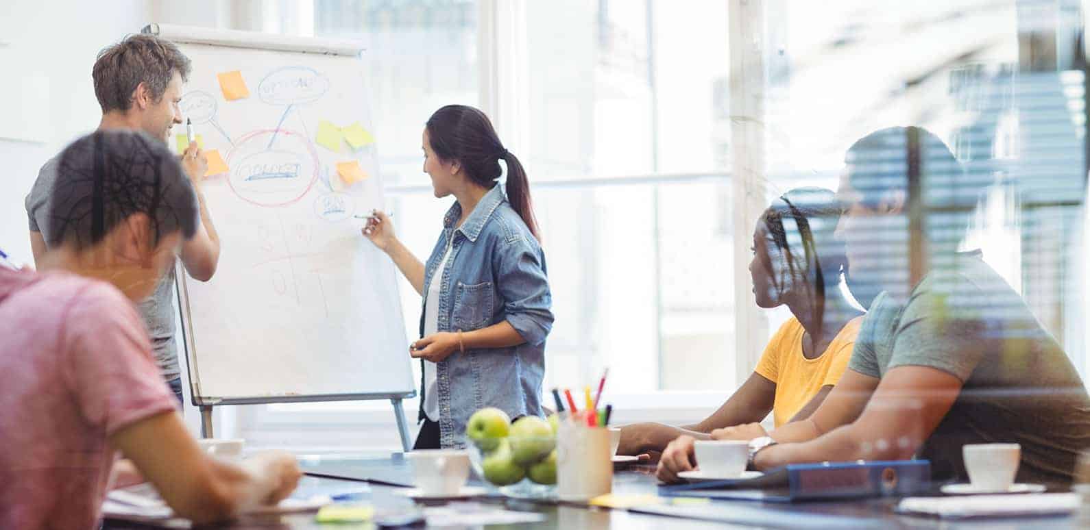 Business executives discussing with their colleagues on whiteboard