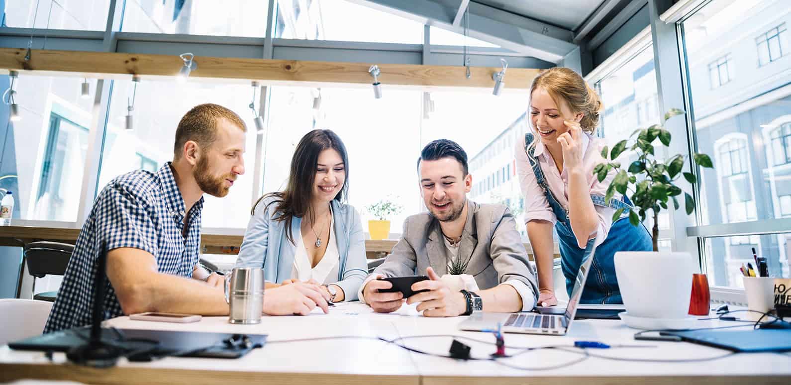 Team watching phone in office