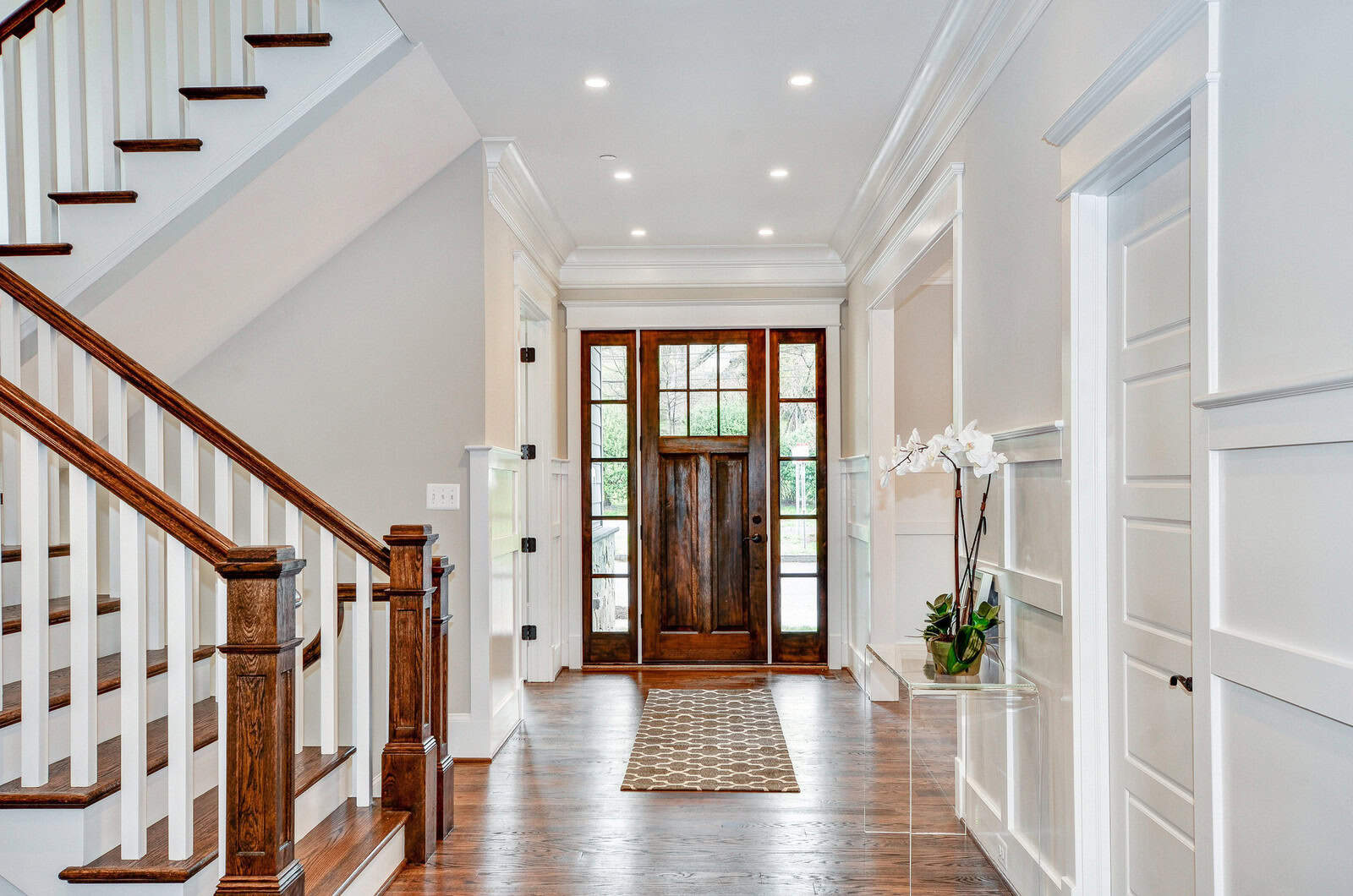 a transitional front door with glossy appearance and white trim