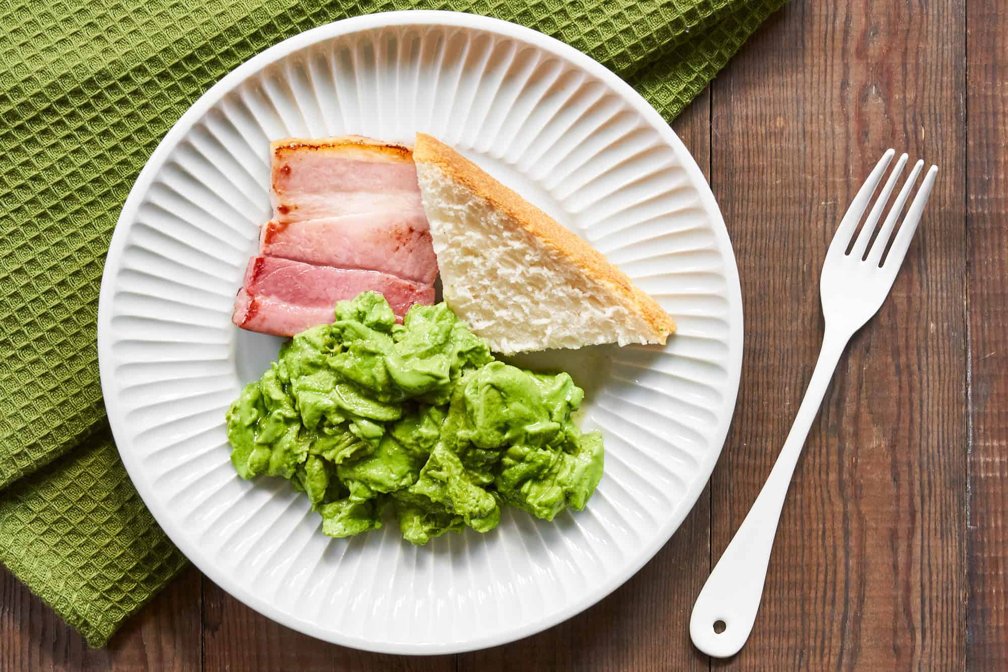 Scrambled green egg whites and ham uses matcha powder to turn the eggs green.