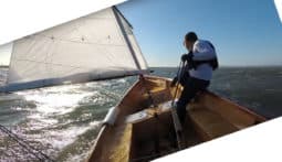 Teo Deus sailing his Goat Island Skiff with one reef in a lot of wind