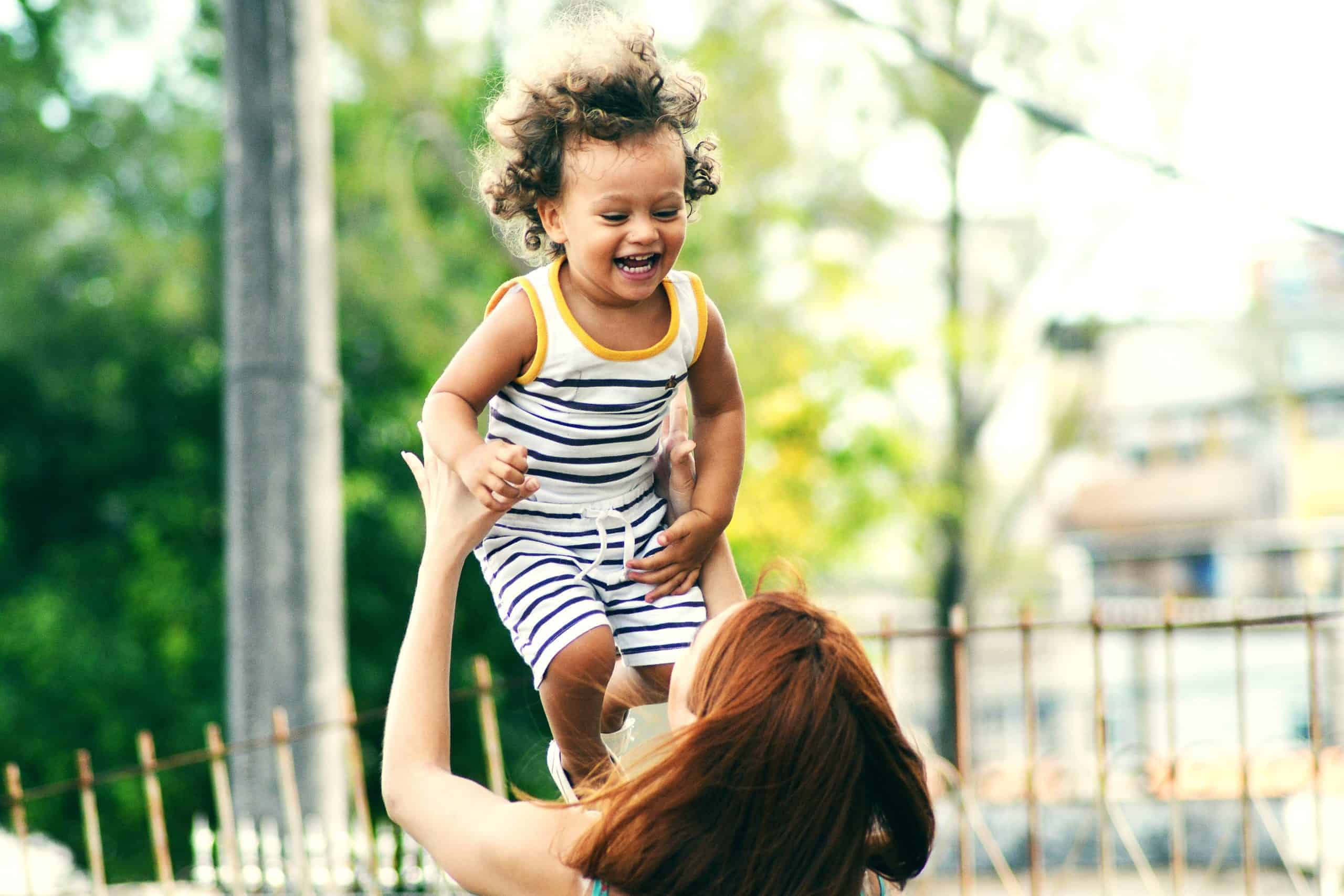 Give Once - Image of mother holding up a child