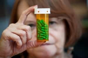 Woman reading instructions on pill bottle