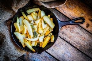 Homemade french fries with rosemary and salt in cast iron skille