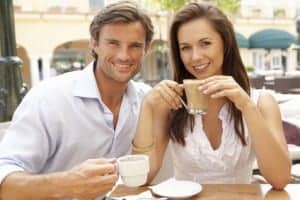 Young Couple Enjoying Coffee And Cake In Caf